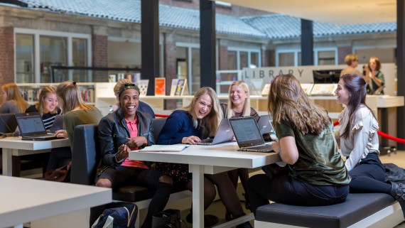 Een groepje lachende studenten voor de BUas library