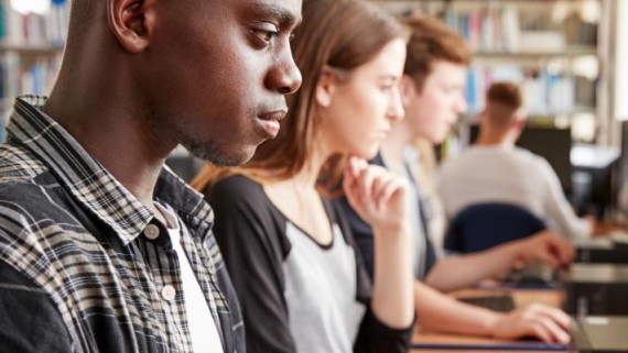 Studenten werken achter desktop computers
