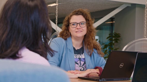 Een docent zit achter een laptop