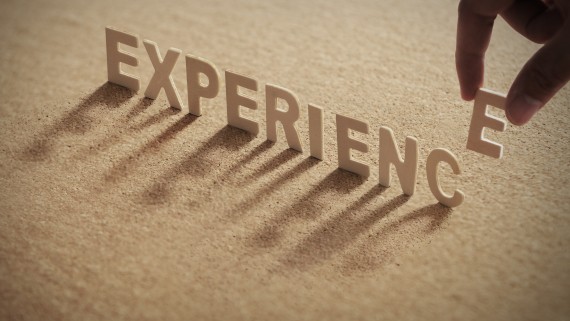 De letters van het woord Experience staan in het zand