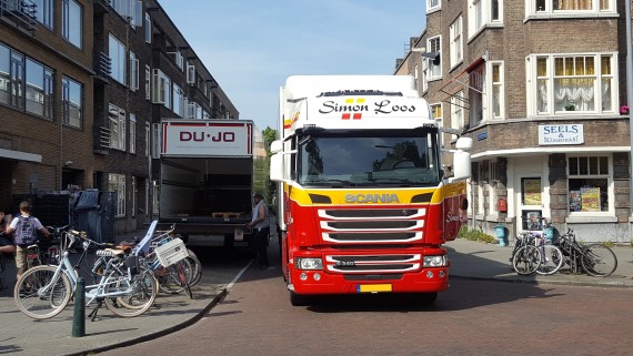 Ee vrachtwagen in een smalle straat