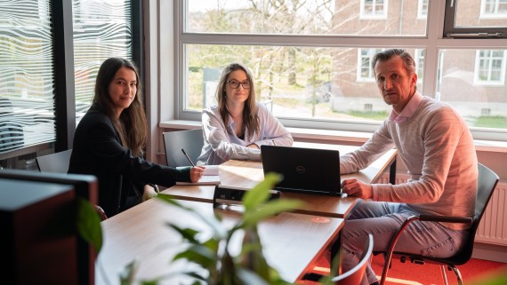 Een docent en twee studenten zijn in overleg