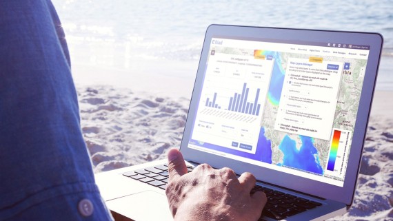 Iemand werkt op een laptop aan het strand