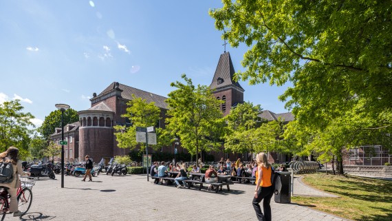Studenten lopen, fietsen en zitten op de BUas campus