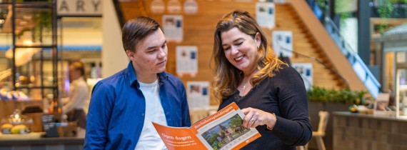 Moeder en zoon bekijken een BUas brochure