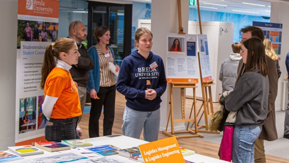 Ouders en studiekiezers praten met studenten op de open dag