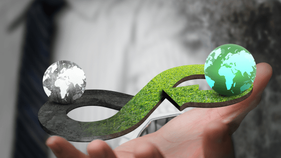 Een hand houdt groene en een donkere wereldbol vast 