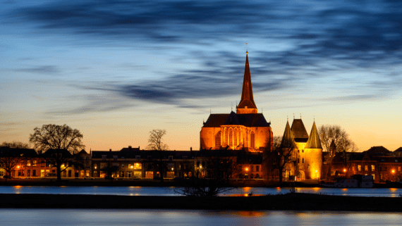Een stad met een kerk aan het water in de avond