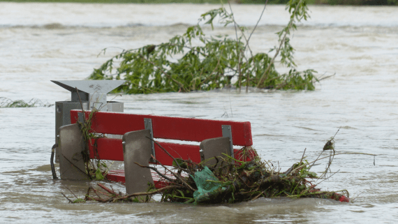 Een bankje staat bijna onder water tijdens een overstroming