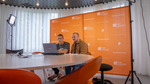 Twee studenten zitten voor een laptop voor de online open dag