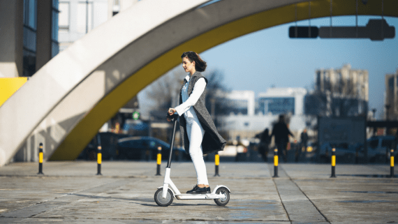 Een vrouw rijdt op een elektrische step 