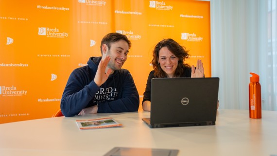 Een student en docent zwaaien naar een laptop