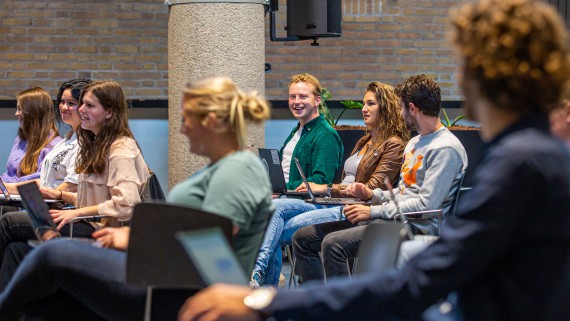 Studenten met een laptops luisteren naar een uitleg