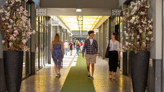Studenten lopen door een overdekte winkelpassage in Breda