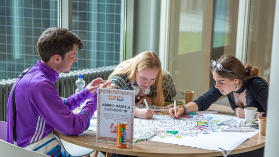 Drie studenten kleuren een mandela in 