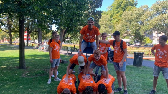 Studenten zitten op elkaar in een menselijke piramide 