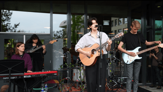 Een band van studenten treedt op op een podium
