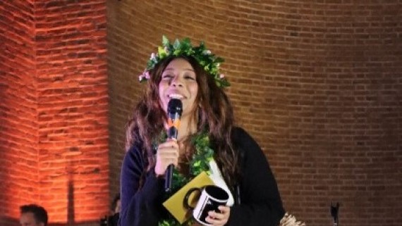 Een student met een bloemenkrans geeft een optreden