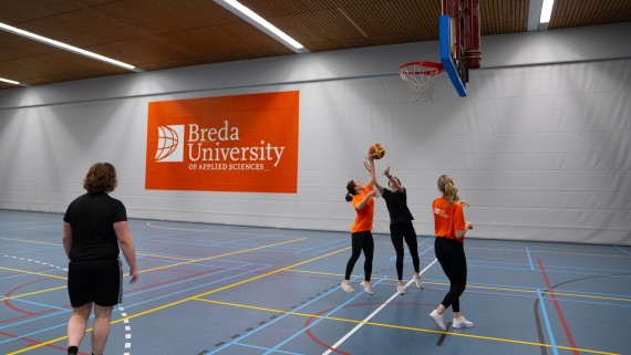 Vier studenten spelen basketbal 