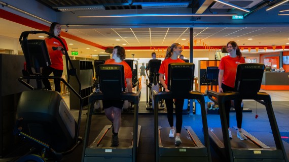 Vier studenten sporten op een loopband in een sportschool