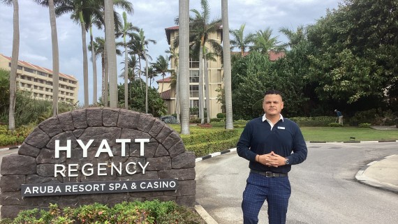 Jean Paul Thijzen staat naast het Hyatt hotel op Aruba