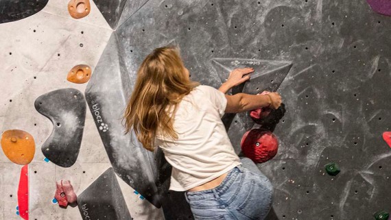 Een student klimt op een boulderwand 