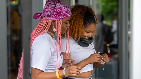 Twee meisjes staan achter een dj-set