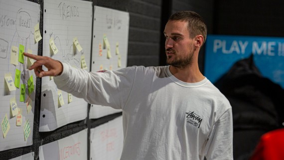 Een student wijst iets aan op een post-it