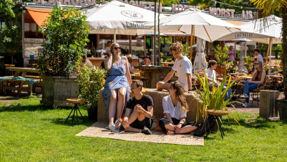 Studenten zitten bij een terras in een park