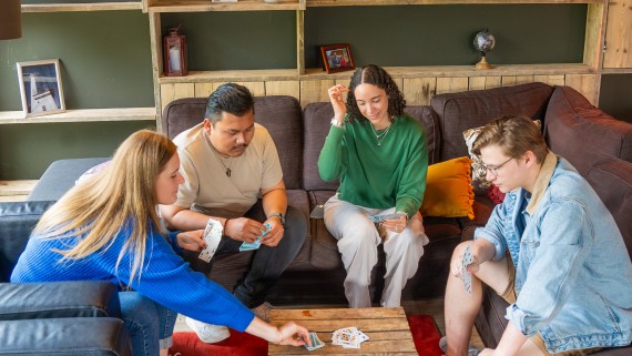 Vier studenten spelen samen een kaartspel