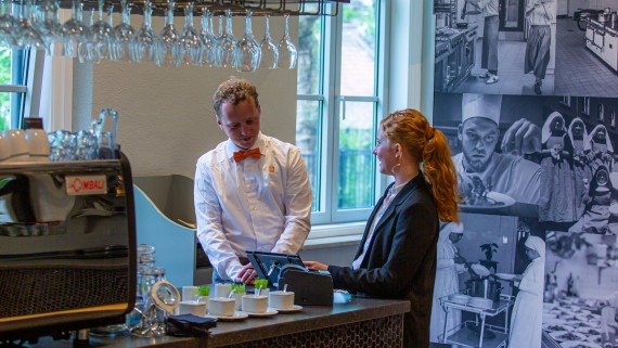 Twee studenten werken bij de bar van een restaurant