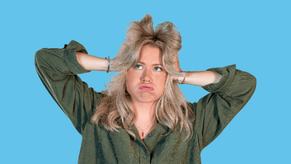 Een meisje heeft haar handen in haar haren en kijkt besluiteloos