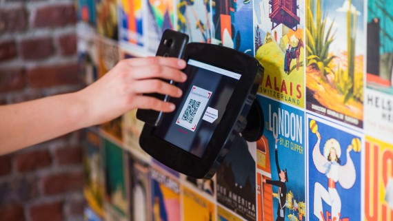 Een telefoon scant een QR-code op een beeldscherm