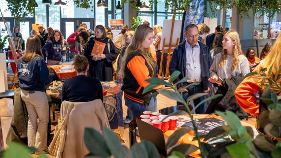 Studenten en docenten praten met bezoekers op de open dag 