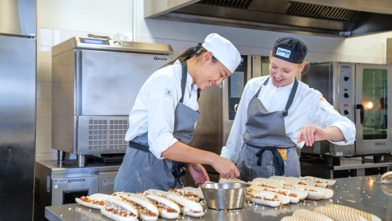 Twee studenten maken broodjes in een keuken