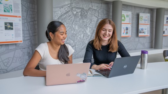 Twee studenten werken op hun laptop