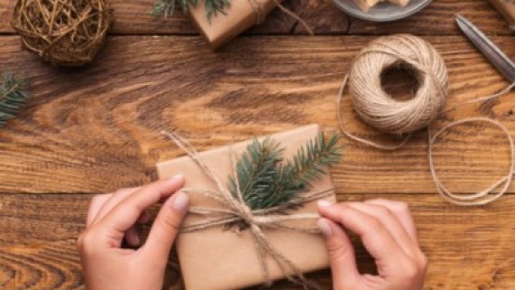 Een vrouw doet een strik om een cadeau