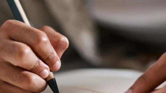 Iemand schrijft met een pen op papier