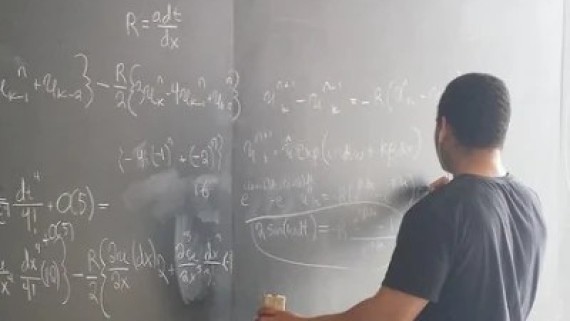 Een jongen schrijft wiskundige formules op een krijtbord