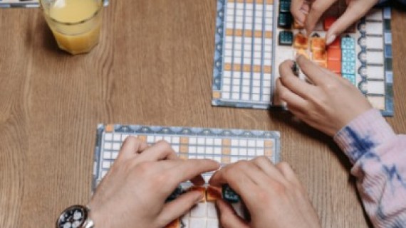 Drie mensen spelen een spel aan een tafel