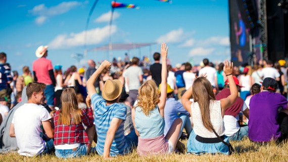 Mensen zitten in het gras op een festival