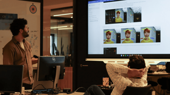 Twee medewerkers bekijken een presentatie op een digibord