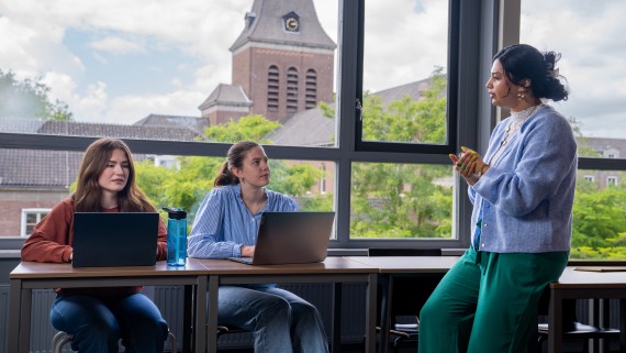 Twee studenten en een docent aan het werk