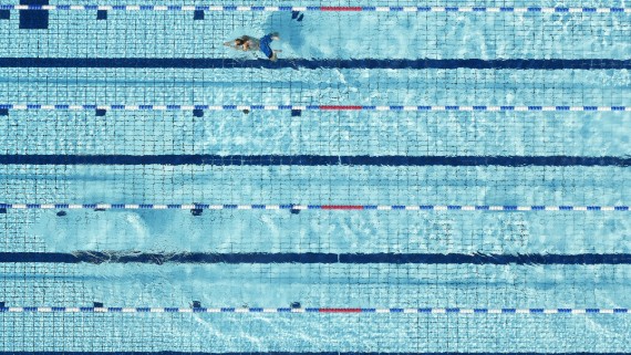 Groot zwembad waar 1 persoon baantjes in trekt