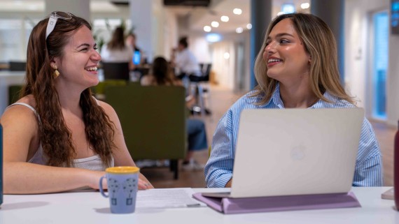 Students laughing and working on a laptop
