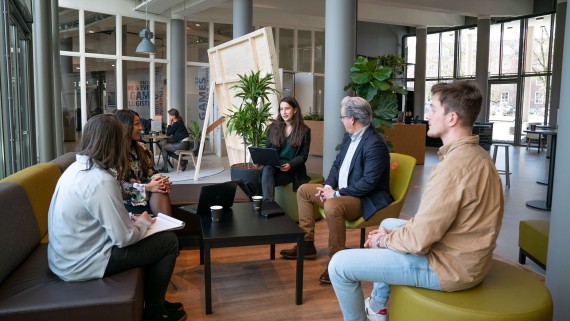 Vijf mensen vergaderen met elkaar