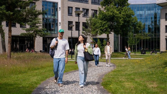 Twee studenten lopen over het campus terrein