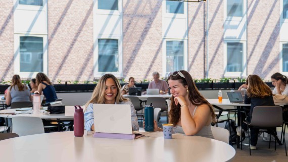 two students with a laptop