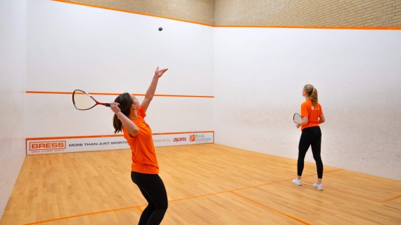 Two students playing squash