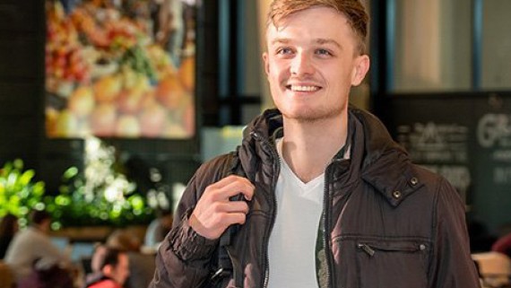 Een lachende student loopt door de school